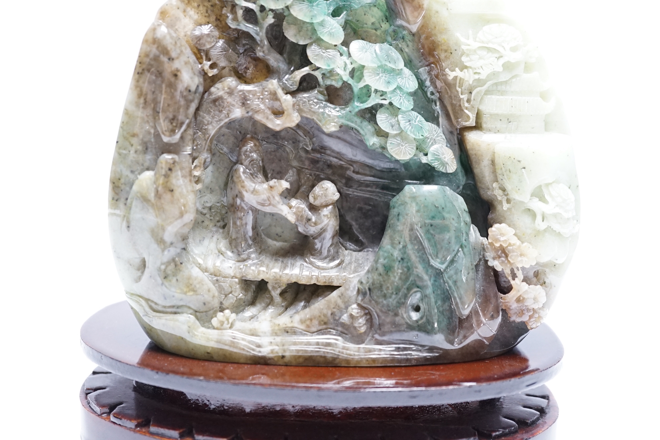 A Chinese jadeite boulder carving on hardwood stand, 17cm high